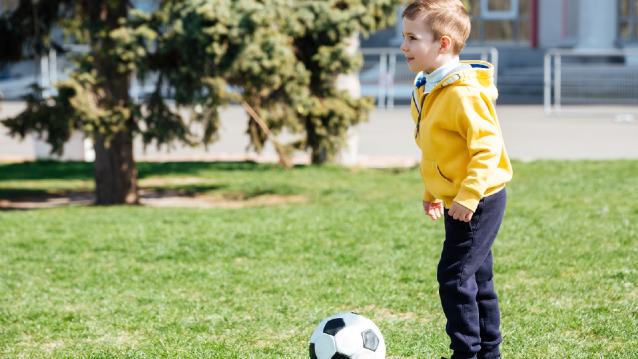 Boy playing football. Детский футбольный мяч в парке. Мальчик с мячом в парке. Мальчики играют в футбол в парке. Футбол детский в детском саду.